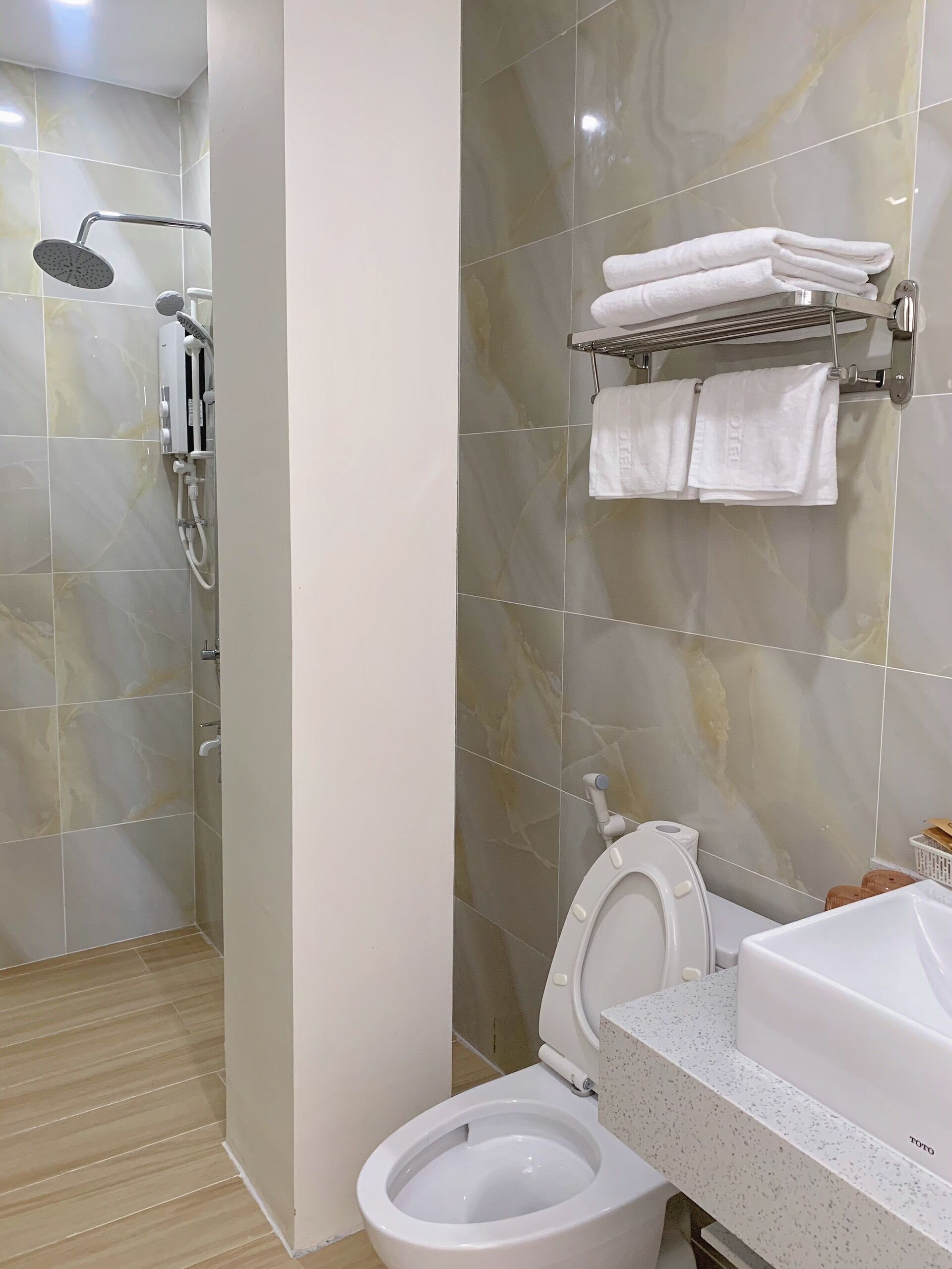 A modern bathroom with a shower, toilet, and sink.