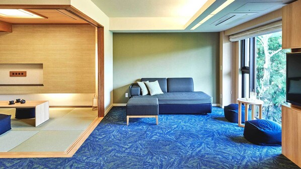 A modern bedroom with a bed, a small table, a bench, and a TV. - Tokyu Vacations Hakone Gora (Hakone)