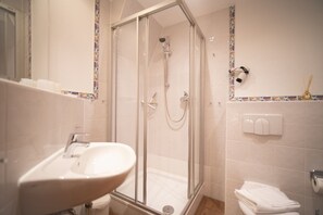 Ein Badezimmer mit Duschkabine, Waschbecken und Toilette.