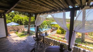 A covered outdoor area with a pool, chairs, and a table. - Pousada Villa Casablanca (Búzios)