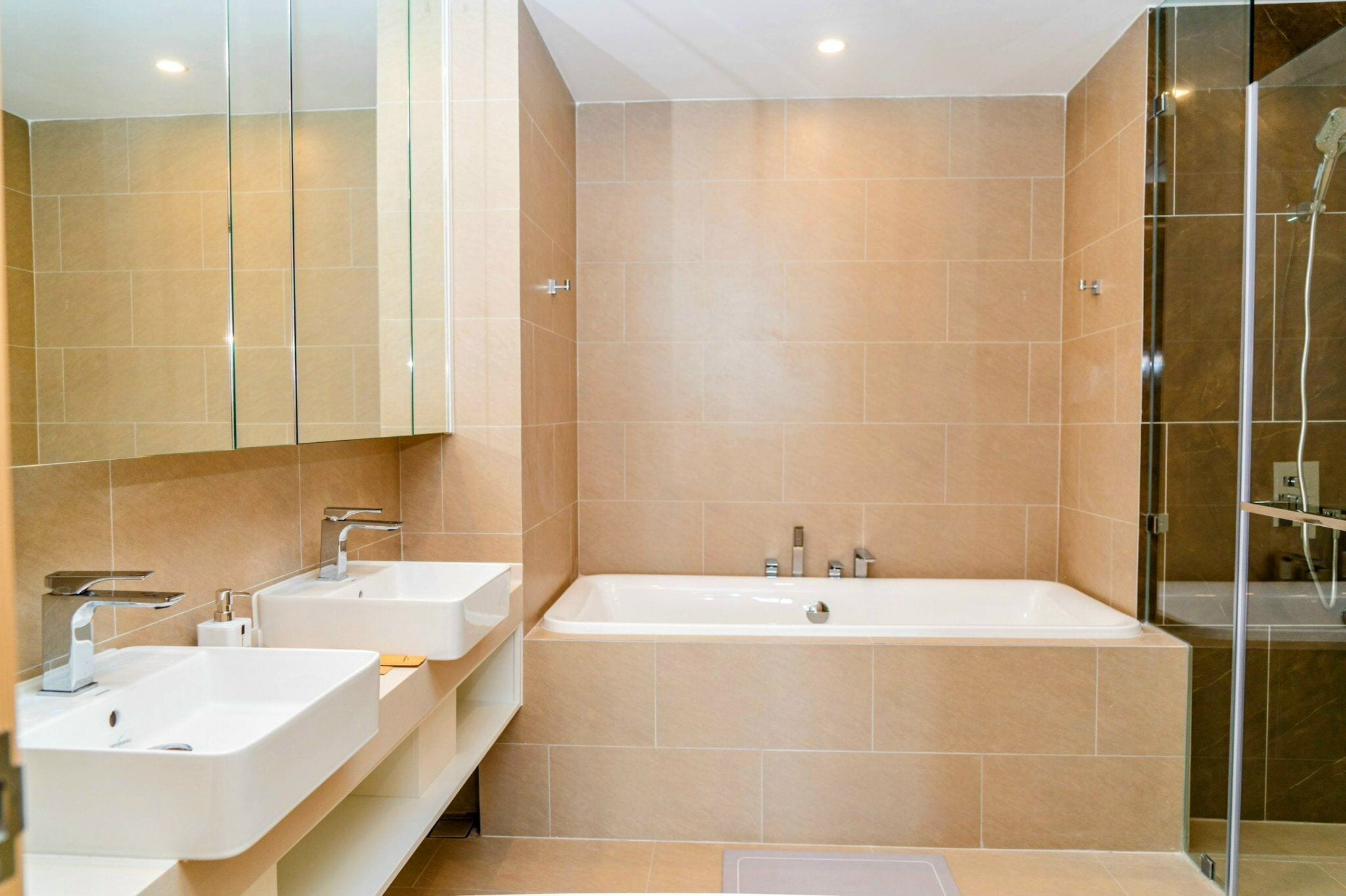 Une salle de bain moderne avec deux lavabos, une grande baignoire et une douche à l’italienne.
