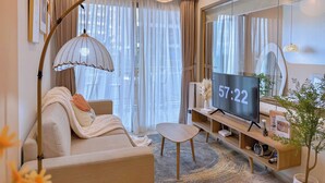 Una sala de estar moderna con un sofá, una mesa de centro, un televisor y un espejo grande.