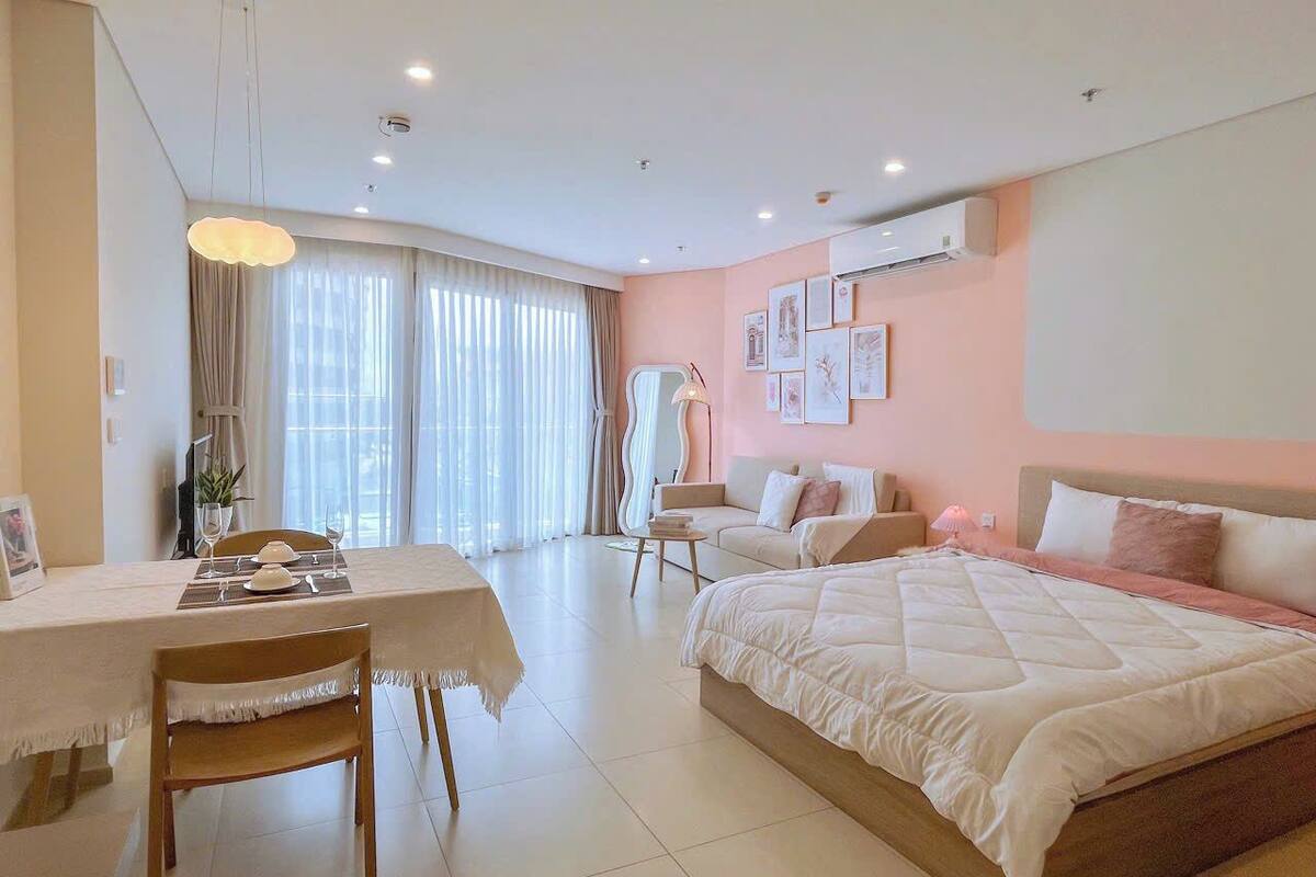 Un dormitorio moderno con una cama grande, una mesa de comedor y un sofá.
