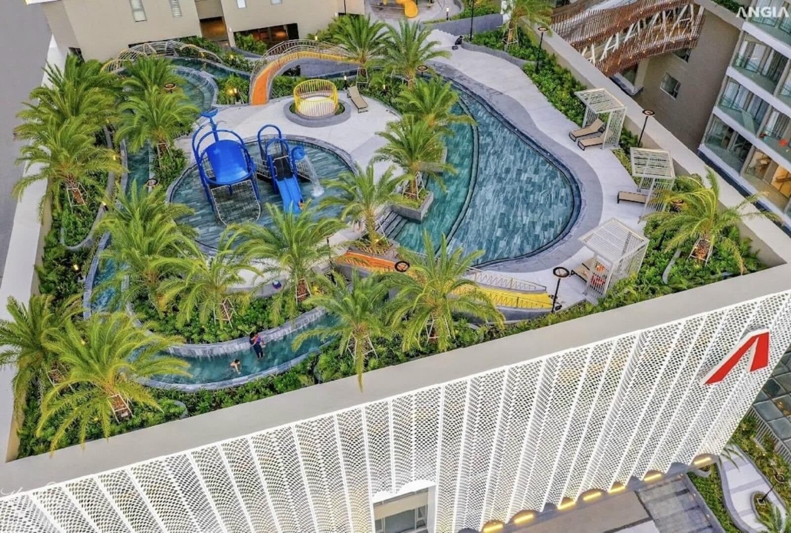 A rooftop pool area with palm trees, a blue slide, and a water feature.