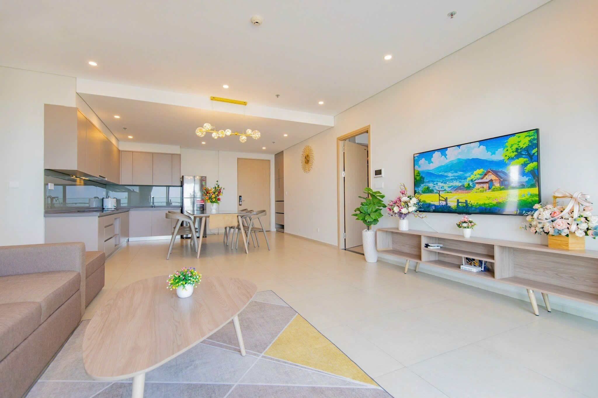 A modern living room with a sofa, coffee table, TV, and a painting on the wall.