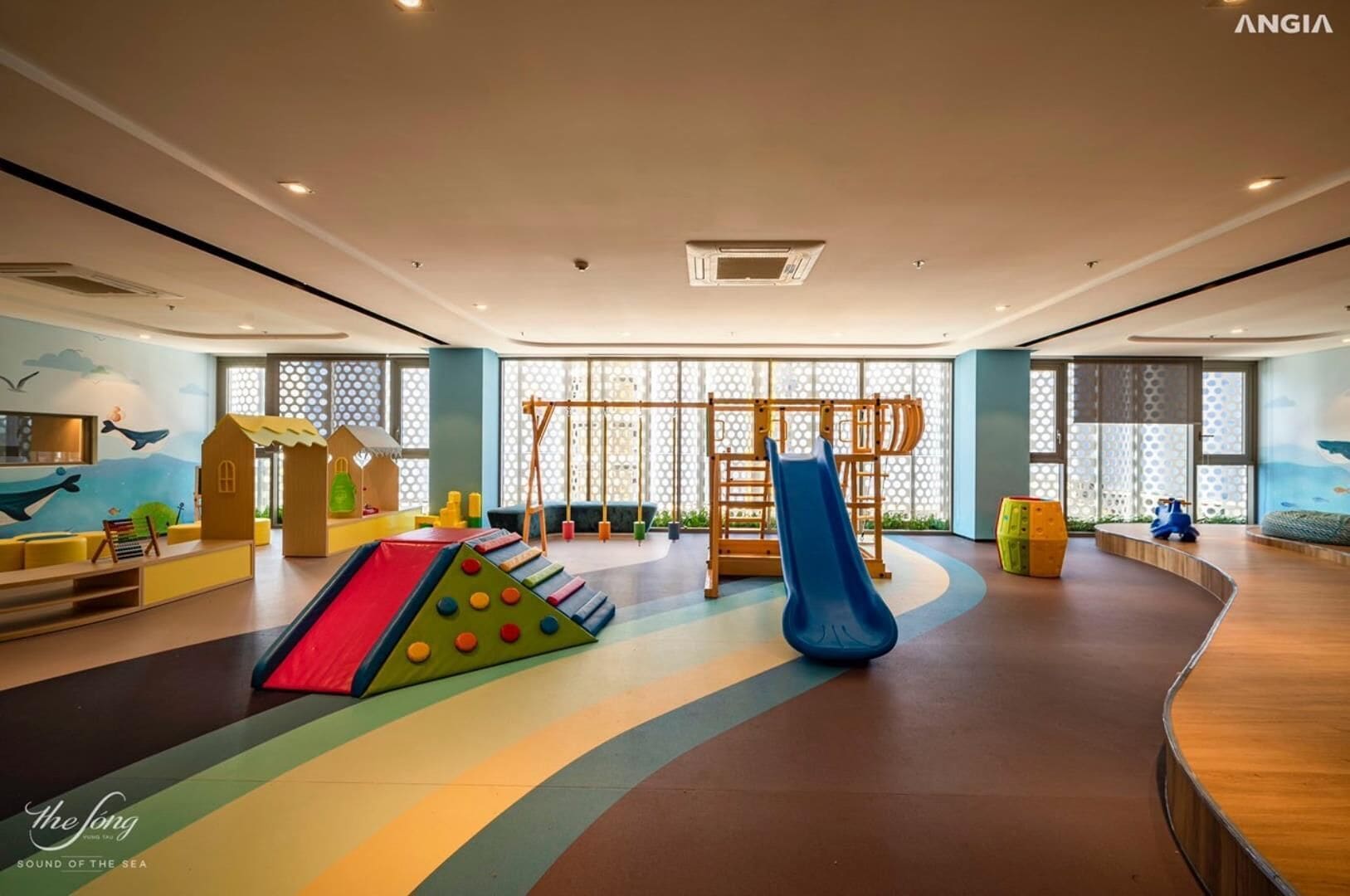 A spacious indoor play area with a slide, climbing wall, and various play structures.