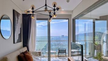 Een moderne woonkamer met een bank, een televisie en een balkon met uitzicht op de stad.