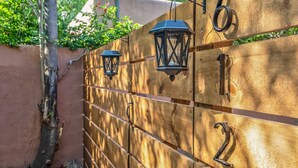 Une clôture en bois, divisée en sections numérotées, et ornée de lanternes suspendues.