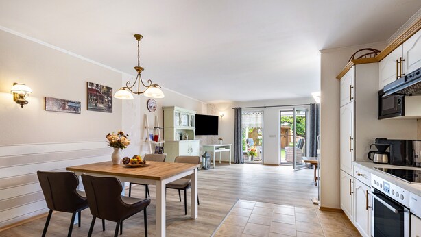 A modern kitchen with a dining area, a TV, and a view of the outdoors. - Holiday Home 'Ferienhaus 75 Qm, 1 Schlafzimmer' with Private Terrace, Shared Garden and Wi-Fi (Neuruppin)