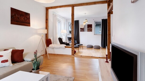 Een moderne woonkamer met een bank, een televisie en een open haard.