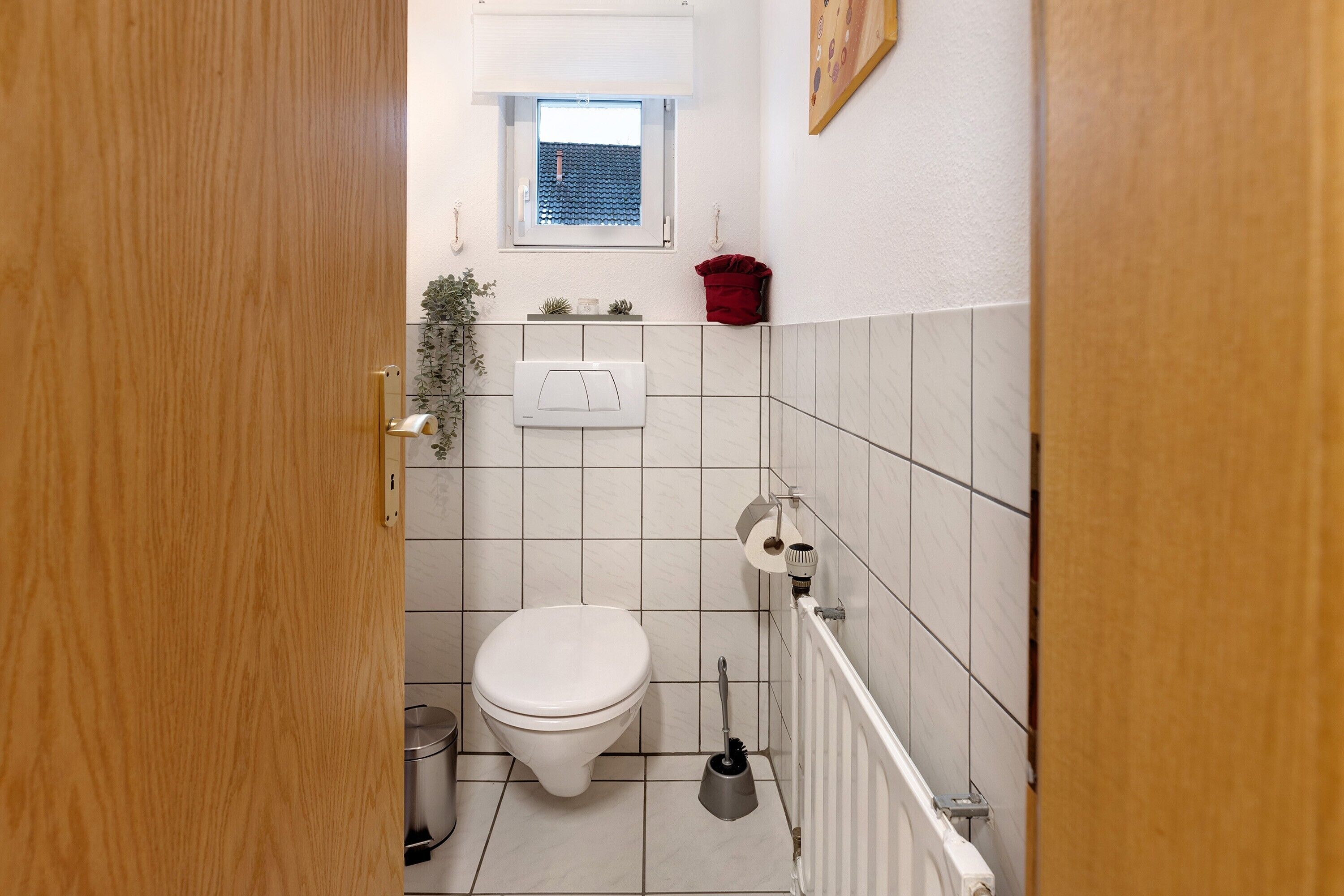 Een badkamer met toilet, bidet en een klein raam.
