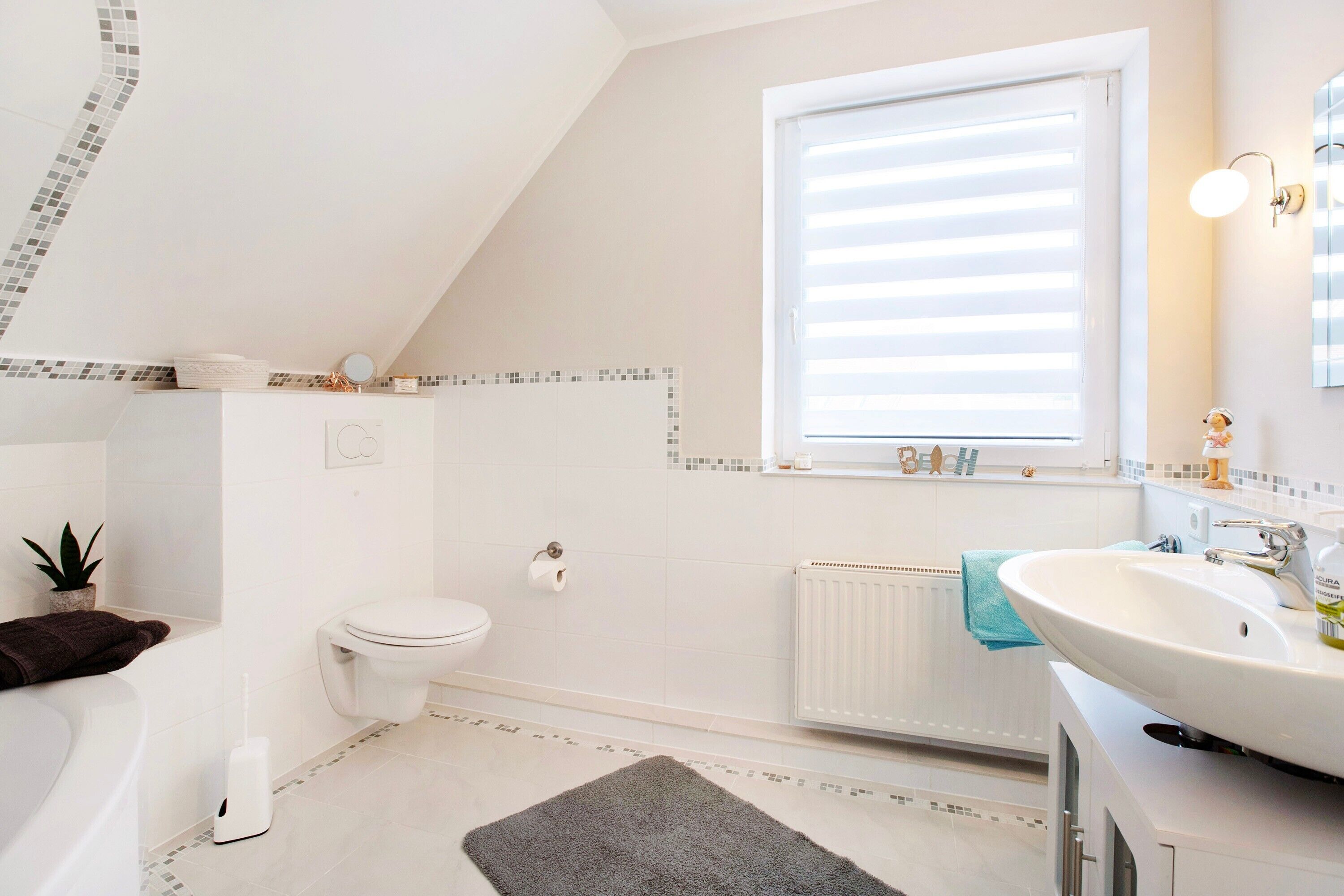 A modern bathroom with a toilet, sink, and bathtub.