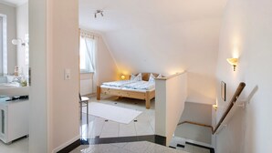 A bedroom with a bed, a nightstand, a lamp, and a window with curtains. - Apartment 'Wendtlandt' with Private Terrace and Wi-Fi (Kappeln)