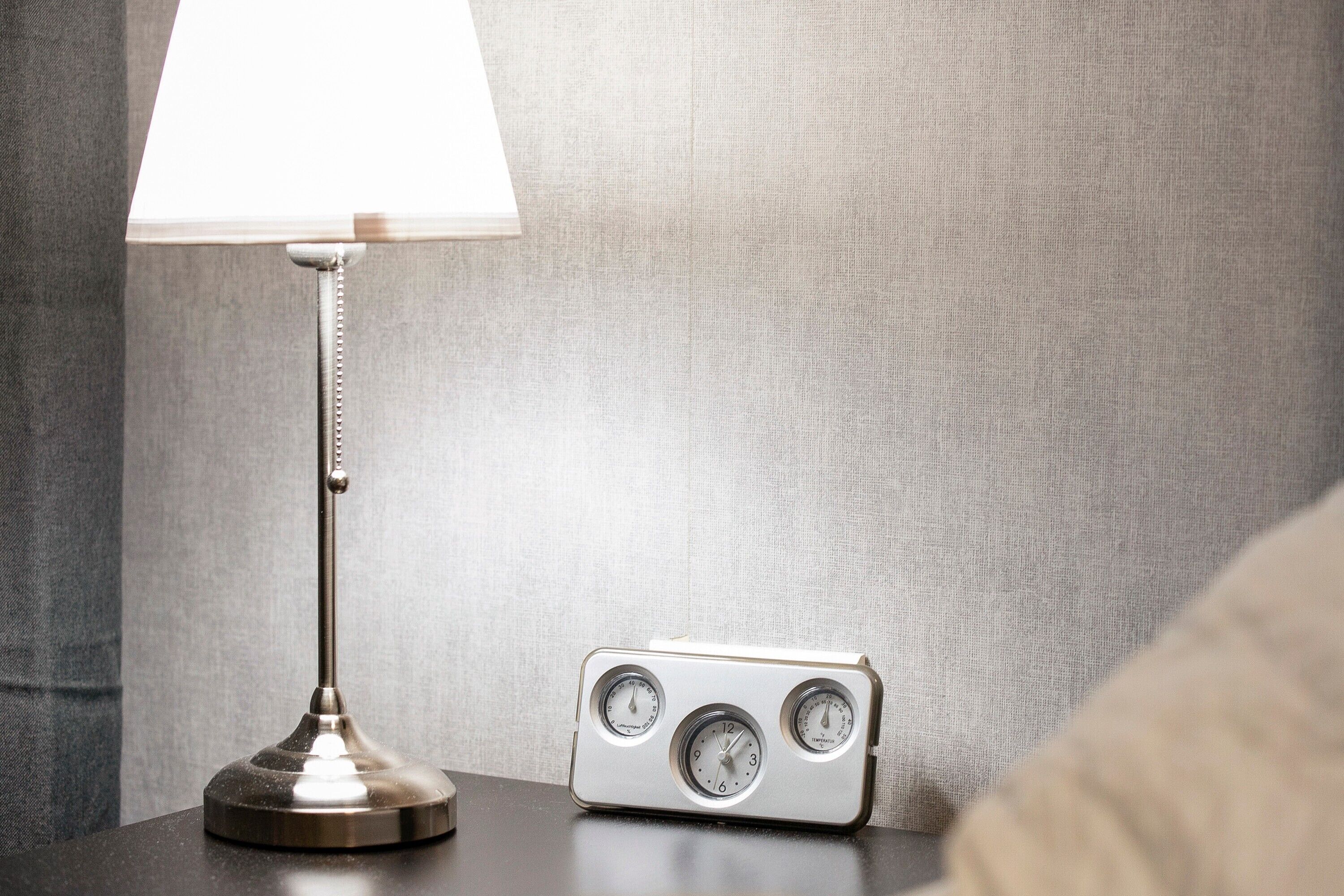 Een nachtkastje met een lamp en een vintage radio.