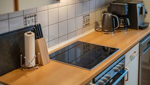Eine Küche mit Herd, Kaffeemaschine und einem Messerblock.