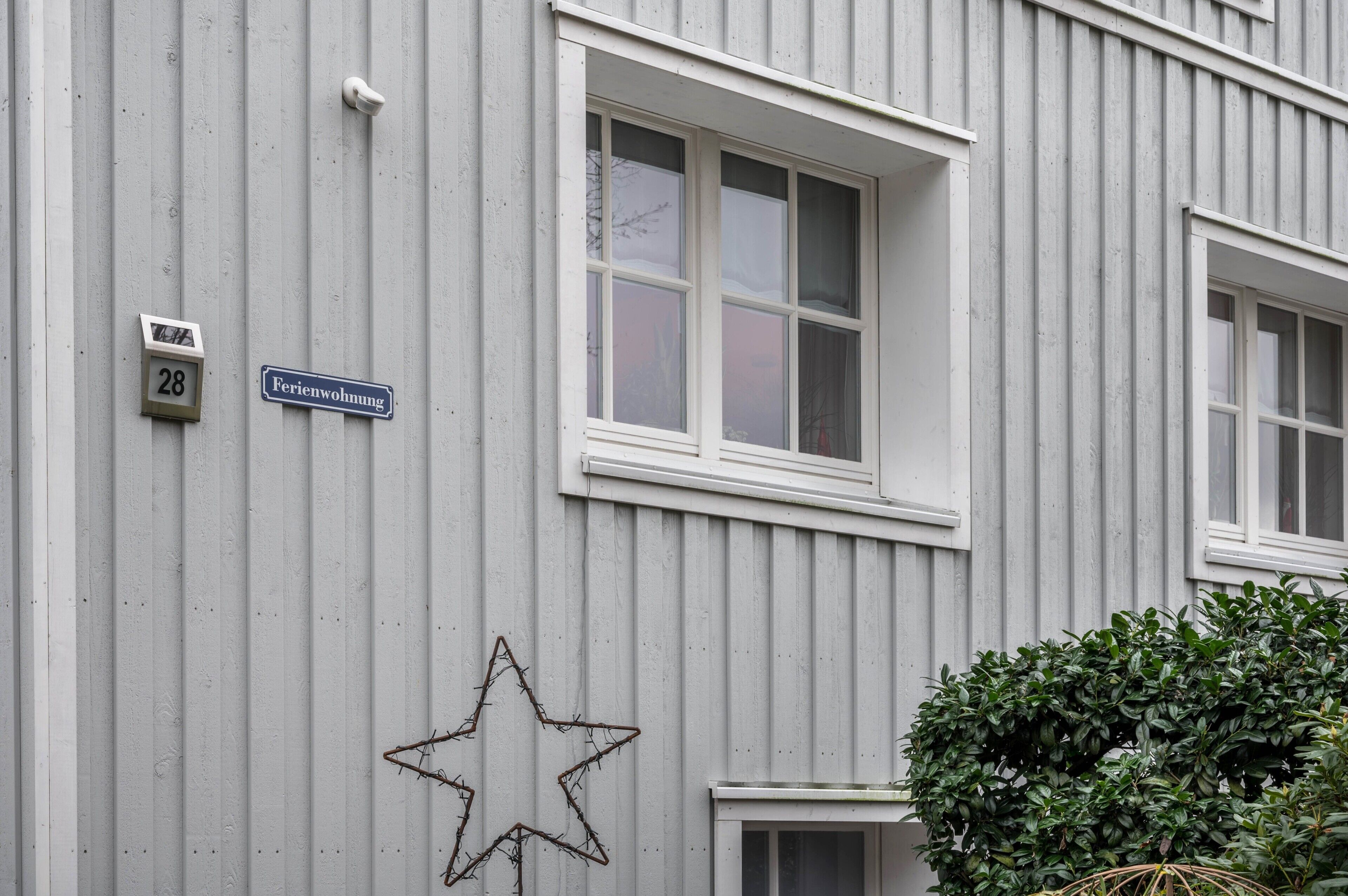 A building with a number '28' and a sign 'Ferienwohnung' indicating a residential unit.
