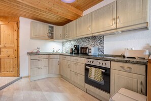 Eine Küche mit Holzausstattung, einer Mikrowelle, einer Kaffeemaschine und einem Toaster.