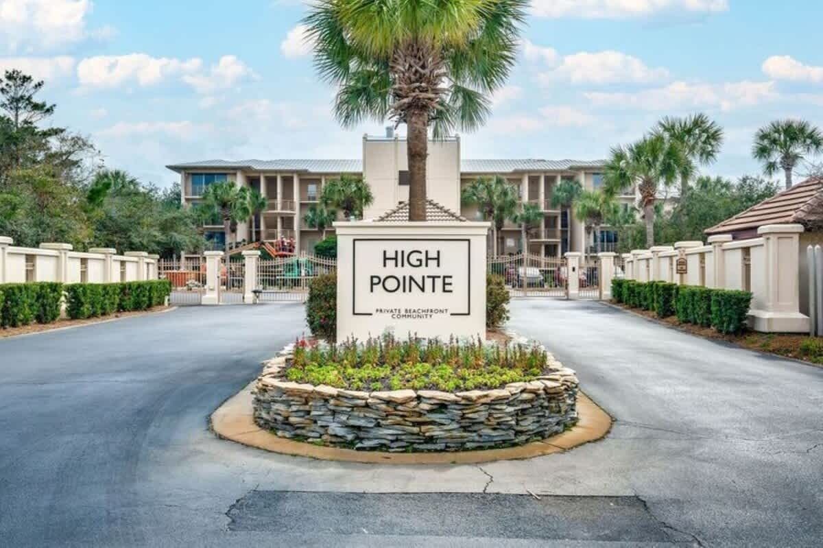 Ein verschlossenes Tor mit einem Schild, auf dem 'HIGH POINTE PRIVATE BEACHFRONT COMMUNITY' steht.