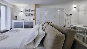 Ein modernes Hotelzimmer mit einem großen Bett, einem Schreibtisch und einem Kleiderschrank.