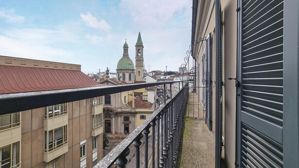 A balcony with a view of a historic building with two towers and a green dome. - Italianway Comfort - Torino 57 A (Milan)