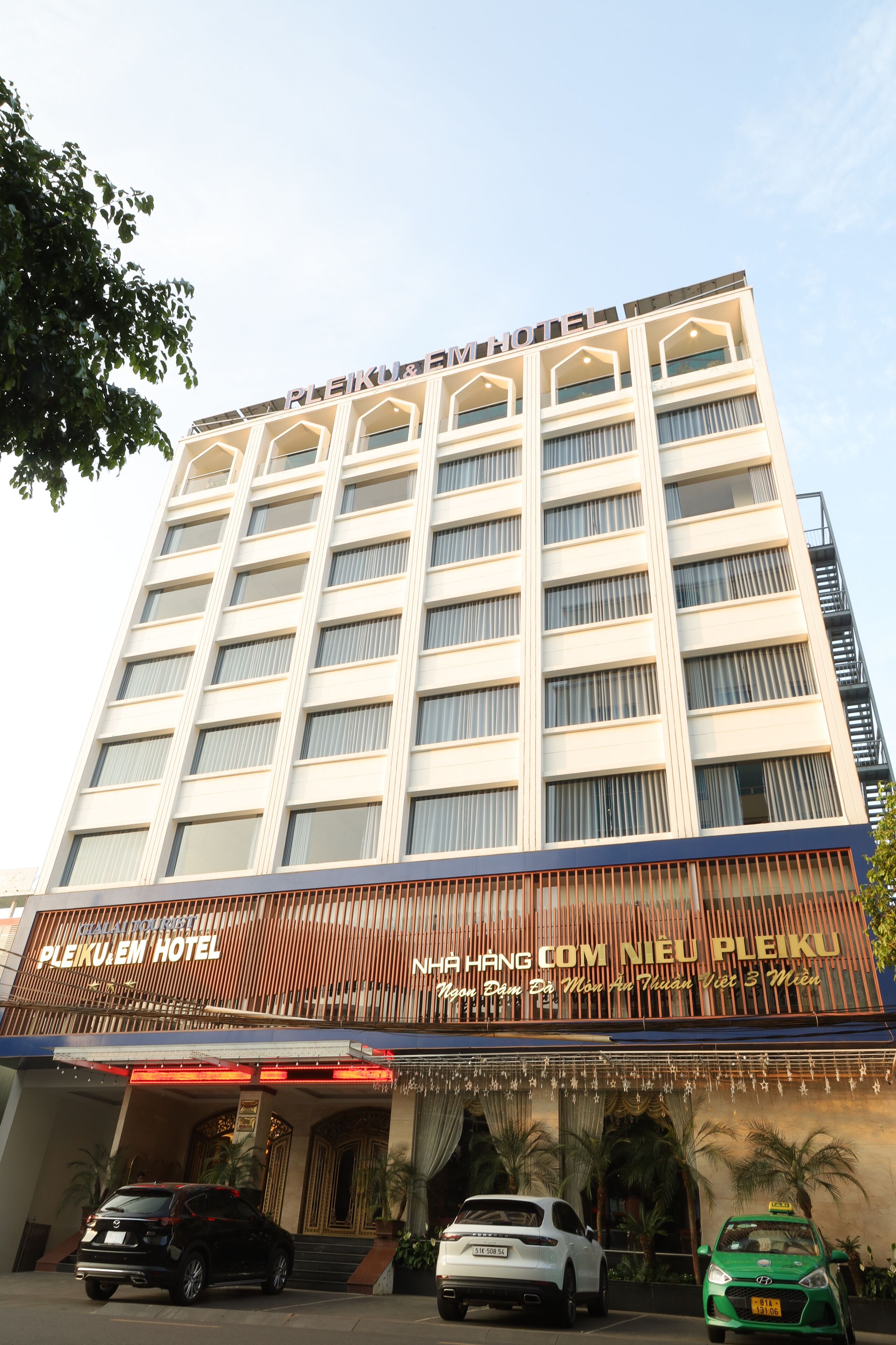 A multi-story hotel with a modern facade, featuring a prominent sign at the top and a welcoming entrance with a covered area.