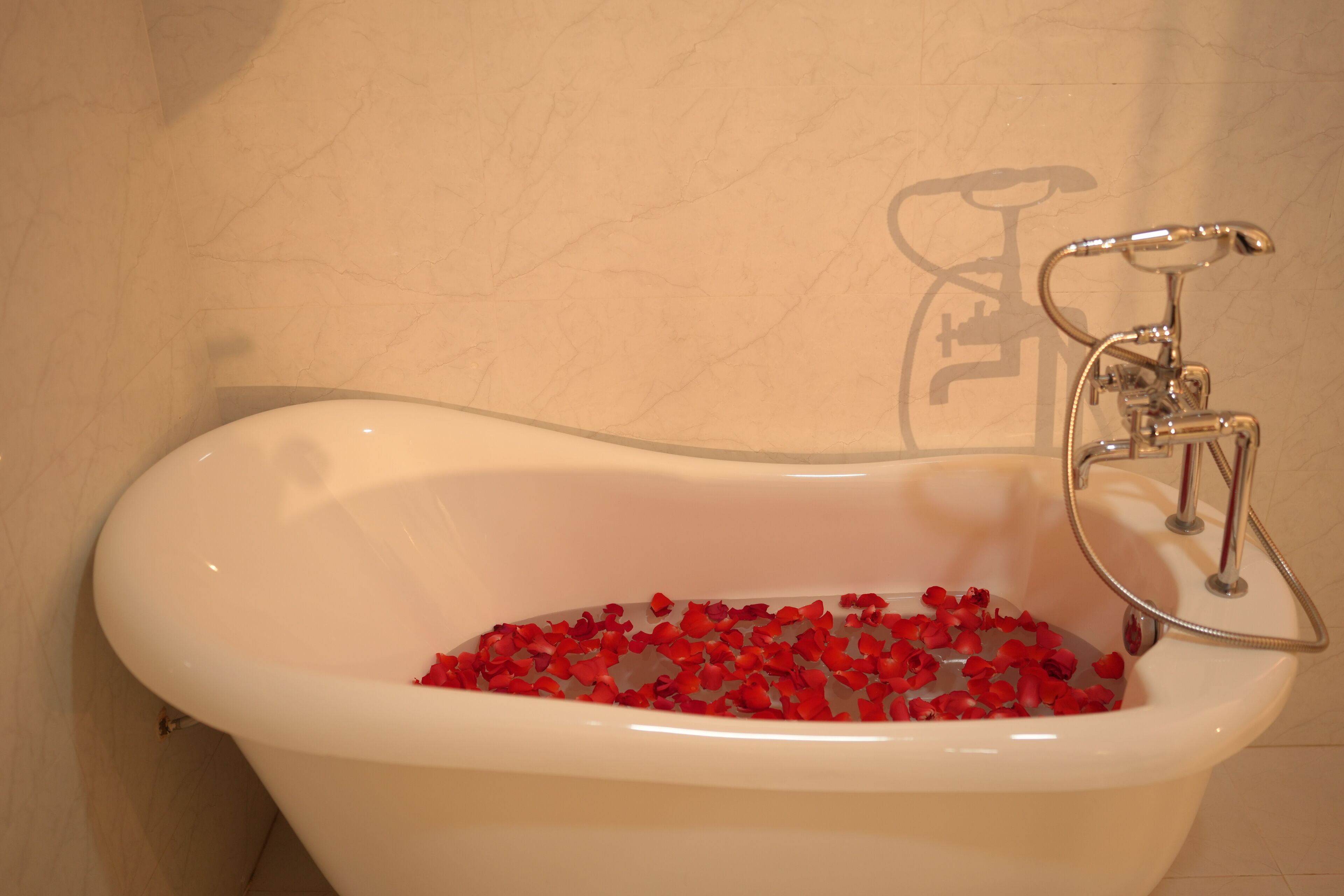 A bathtub filled with red rose petals.