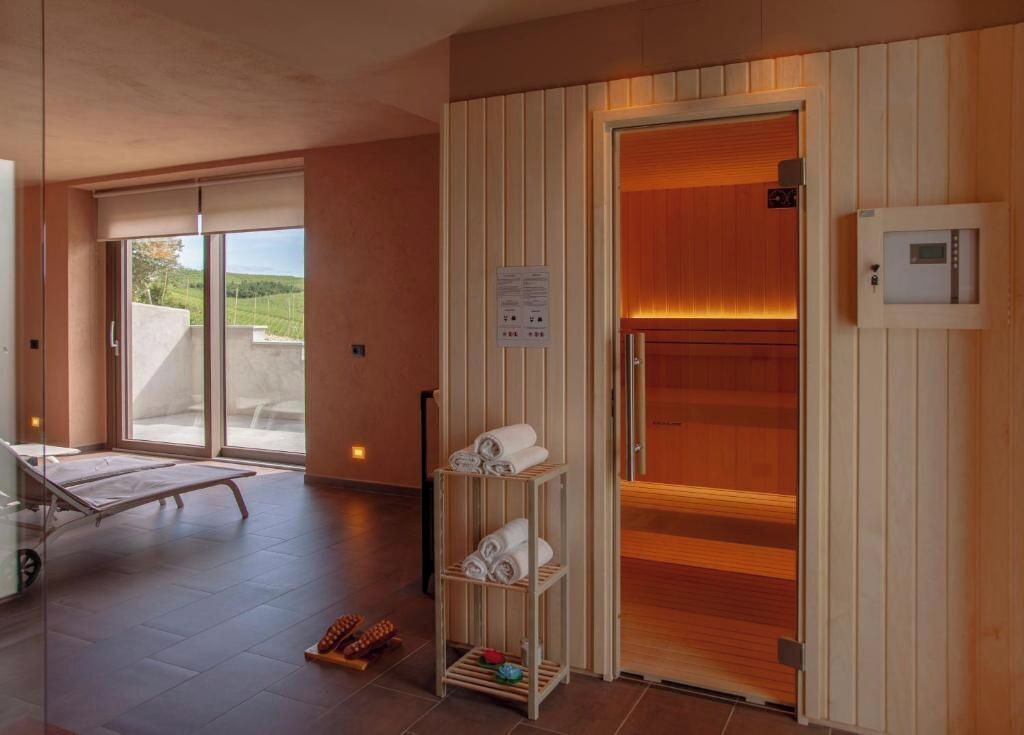 Ein moderner Spa-Bereich mit Sauna, einer Massagebank mit Glastrennwand und einer Ablage für Handtücher.