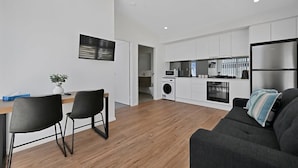 Een modern appartement met keuken, eethoek en zithoek.