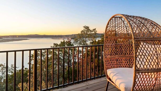A wicker chair on a balcony overlooking a body of water and distant hills. - Waterfront / Pool / Hot tub / Boat Dock (Leander)