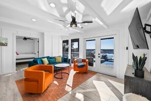 A modern living room with a sofa, armchairs, a coffee table, and a ceiling fan. - Waterfront | Pool | Hot tub | Boat Dock (Leander)