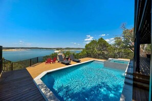 A swimming pool with lounge chairs and a view of the sea. - Waterfront | Pool | Hot tub | Boat Dock (Leander)