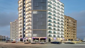 A multi-story hotel with a prominent "HOTEL" sign at the top. - OYO Townhouse 156 Rose Hotel Apartments. (Seeb)