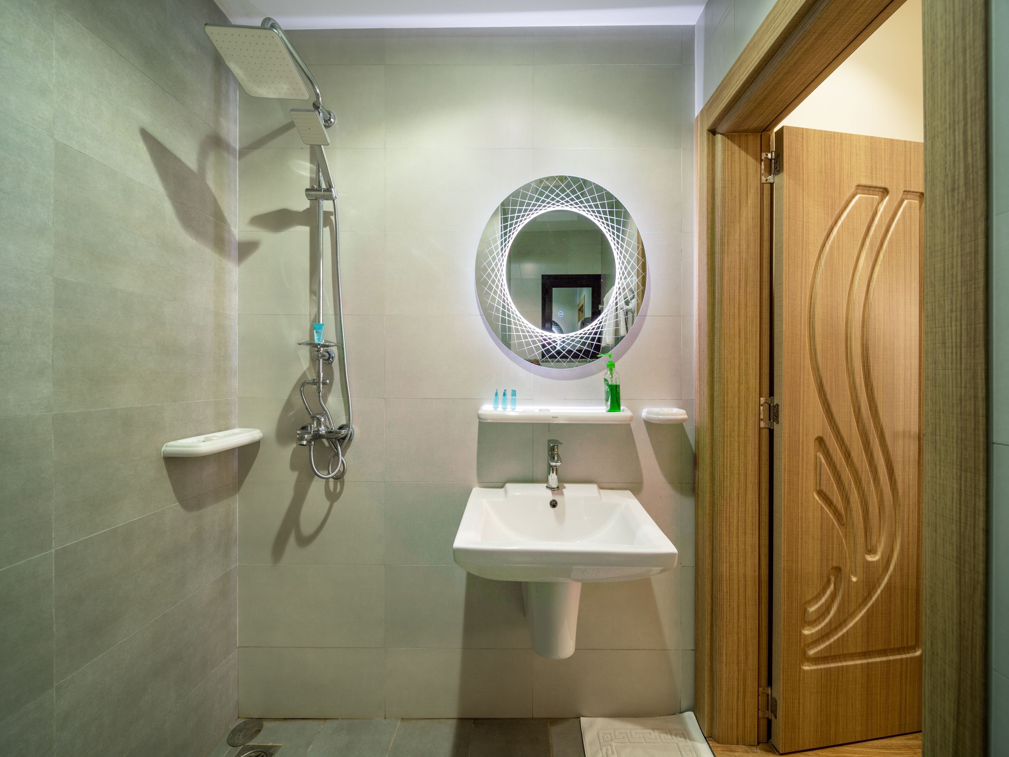 A bathroom with a shower, sink, and mirror.