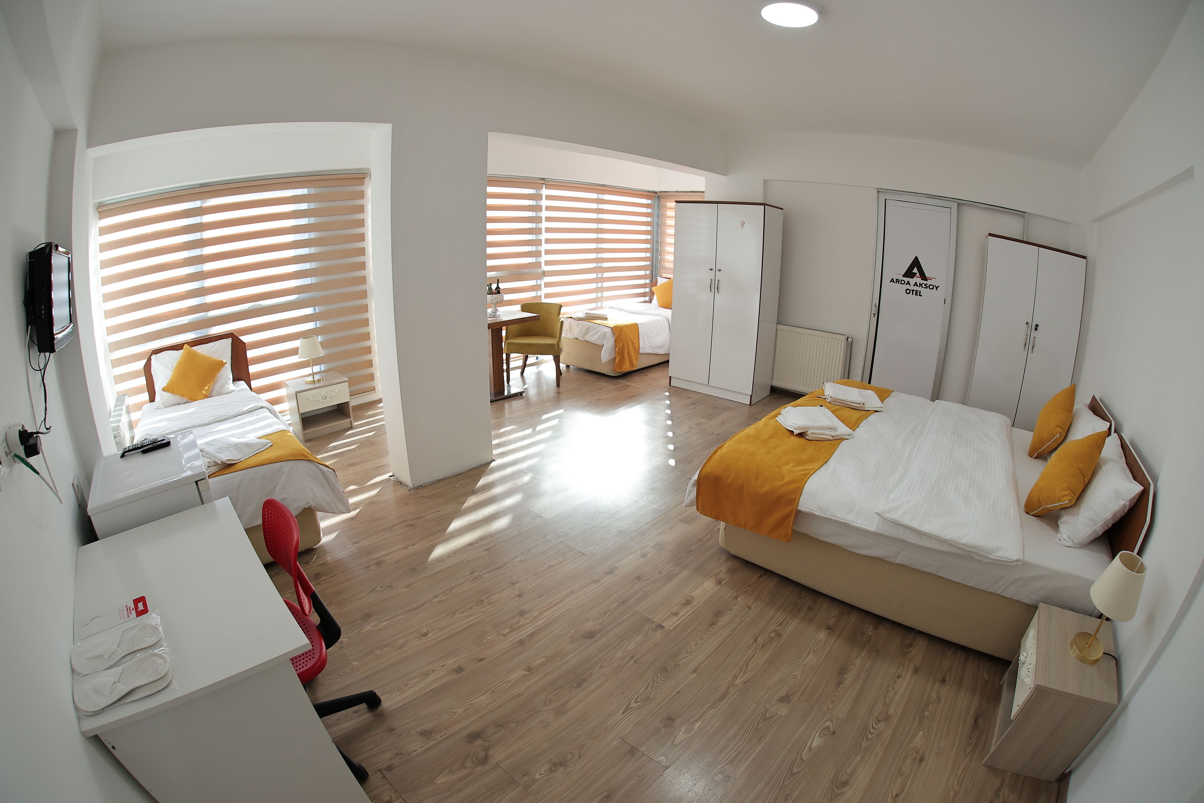 Una habitación de hotel con dos camas, un escritorio, una silla y un armario.