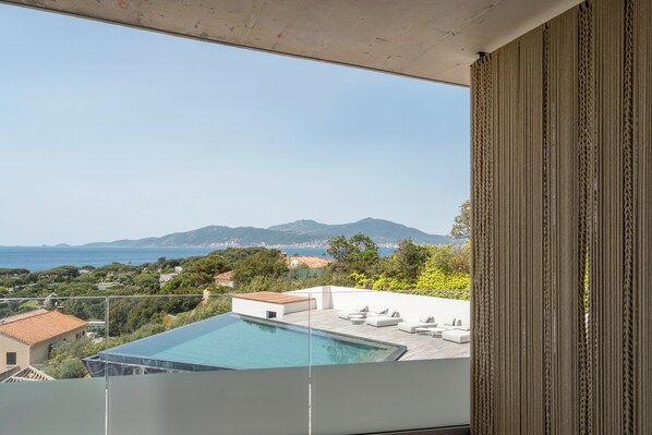 A modern balcony with a clear view of a swimming pool, a wooden deck, and a mountainous landscape in the background. - Villa Urbana (Grosseto-Prugna)