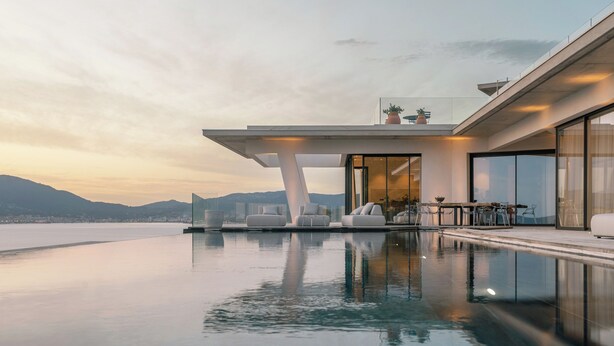 Une piscine à débordement moderne offrant une vue dégagée sur les montagnes en arrière-plan.