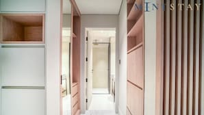 A hallway with built-in wooden shelving and a tiled floor. - Modern Studio Apt w Burj Khalifa View (Dubai)