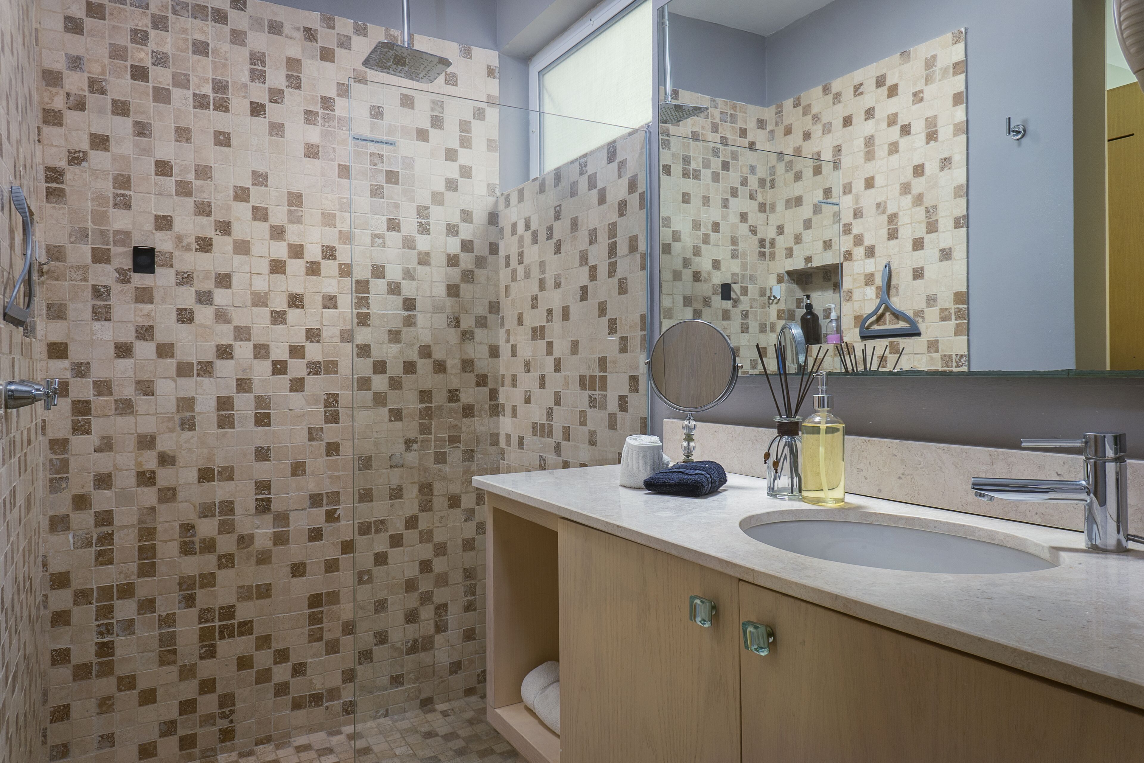 Une salle de bain avec une douche, un lavabo et un miroir.