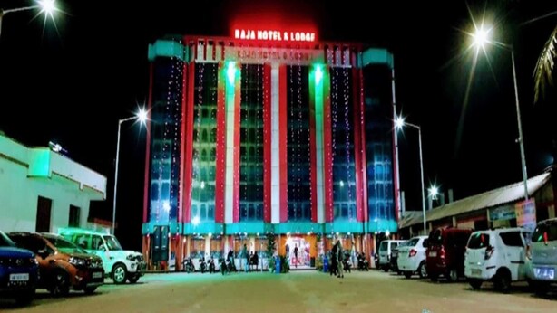 A hotel with a large, illuminated facade and a spacious parking area. - RAJA HOTEL AND LODGE  (Kharagpur)