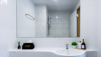 Ein modernes Badezimmer mit Waschbecken, Spiegel und Dusche.
