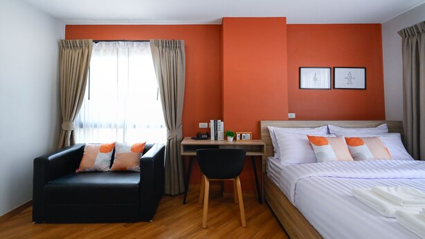 A hotel room with a bed, a desk, a chair, and a sofa. - You Hotel (Bangkok)