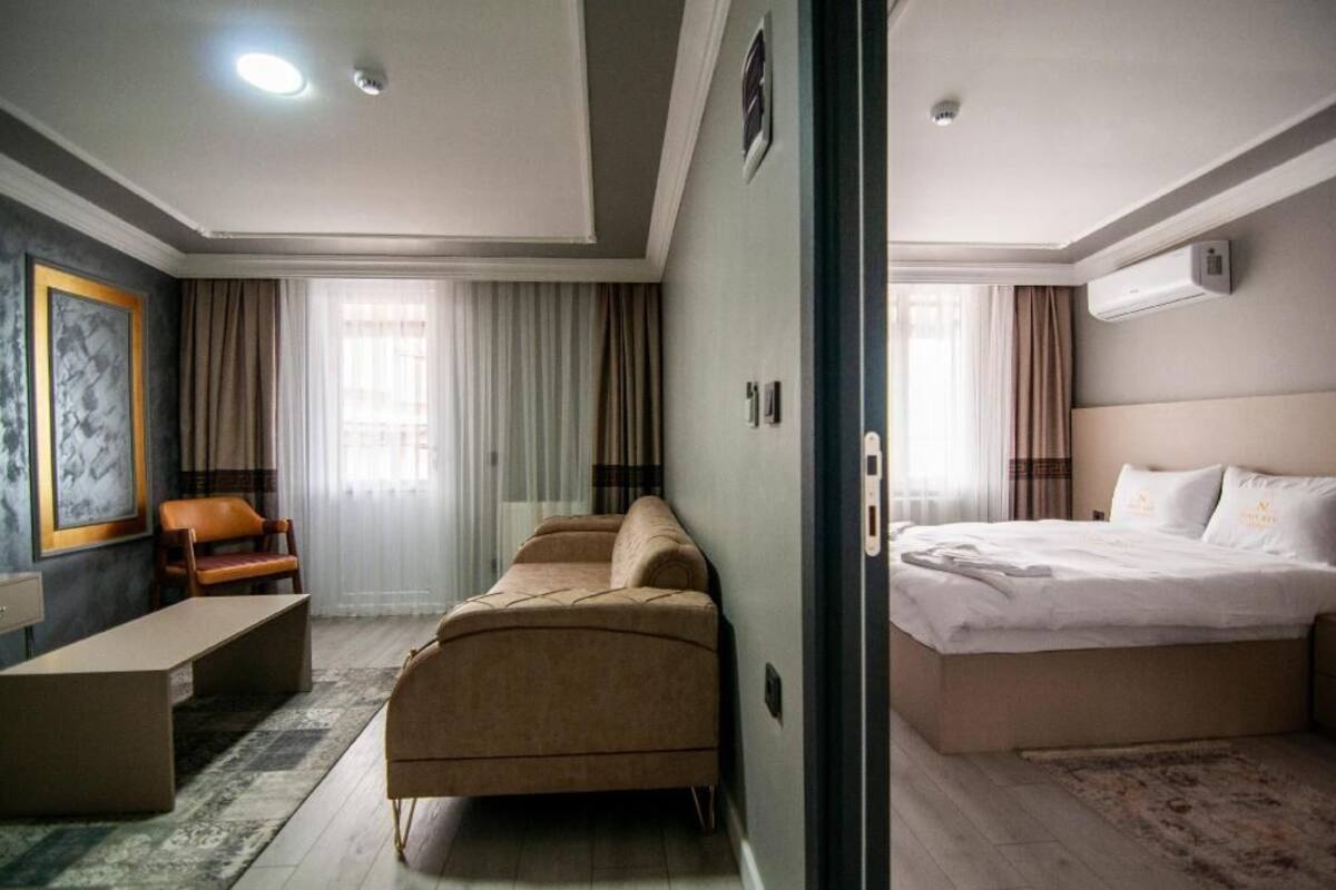 Una habitación de hotel con cama, sofá, escritorio y una silla.