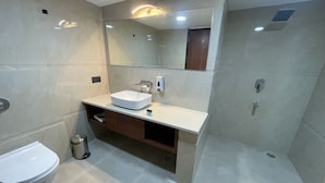 A modern bathroom with a white sink, mirror, and toilet. - The Kedar Resort (Mathura)