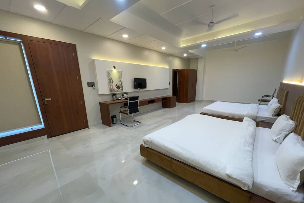 Une chambre d’hôtel moderne équipée de deux lits, d’un bureau, d’une chaise et d’un téléviseur.