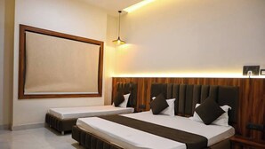 A hotel room with two beds, a large window, and a wooden headboard. - The Kedar Resort (Mathura)