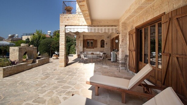 A stone courtyard with a lounge area, outdoor seating, and a view of the surrounding buildings. - Beautiful, Unique, 'stone-built villa on the outskirts of Peyia  (Peyia)