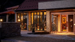 A modern building with a stone facade, large windows, and a welcoming sign. - Hotel Kaze no yama (Iida)
