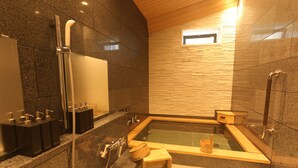 A modern bathroom with a freestanding bathtub, a shower area, and a small wooden stool. - Hotel Kaze no yama (Iida)