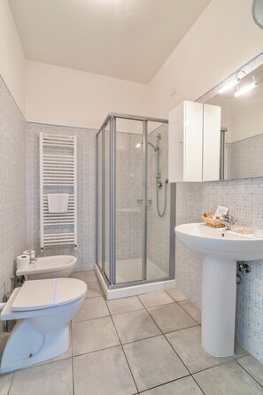 Enjoy a refreshing shower in this bathroom with a clear enclosure, sink, and toilet.