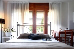 Relax in this serene bedroom with a large bed, bedside table, and desk area.